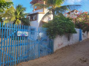 a blue fence in front of a house at Chalé Flor do Ser in Canoa Quebrada