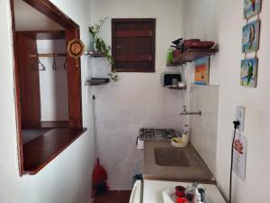 a small kitchen with a sink in a room at Chalé Flor do Ser in Canoa Quebrada