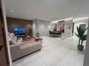 شقة فاخرة جديدة في الملقا Luxury في الرياض: غرفة معيشة فيها أريكة وتلفزيون
