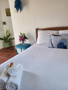 a bedroom with a bed with towels on it at Chalé Flor do Ser in Canoa Quebrada