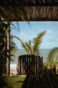 uma vista para a praia a partir de um banco de madeira em Pousada Casa Mar pé na areia em Caraíva