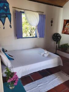 a bedroom with a bed and a window at Chalé Flor do Ser in Canoa Quebrada