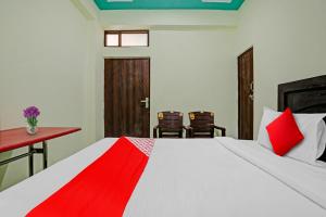 - une chambre avec un lit, un bureau et des chaises dans l'établissement OYO Flagship Green Well Hotel & Restaurant, à Rewāri