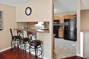 a kitchen with bar stools and a black refrigerator at Overland Park ( I 35, Hwy. 69, and 87 th St. ) in Overland Park