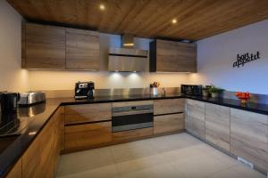 a large kitchen with wooden cabinets and appliances at Chalet Julero - OVO Network in Le Grand-Bornand