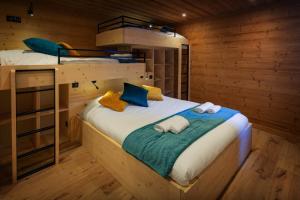 a bedroom with a bed with two bunk beds at Chalet Julero - OVO Network in Le Grand-Bornand