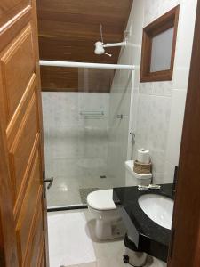 a bathroom with a toilet and a sink and a shower at Pousada Chalé dos Ipês in Santa Teresa