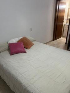 ein großes weißes Bett mit zwei Kissen darauf in der Unterkunft Las Emes in Suipacha