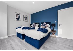 a bedroom with two beds with blue walls at Lovely 4 bedroom with Outdoor space! in London