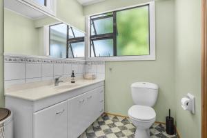 La salle de bains est pourvue de toilettes, d'un lavabo et d'un miroir. dans l'établissement Farley Avenue Turret & Lounge, à Greytown