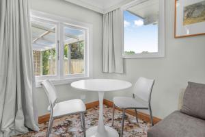 a living room with a table and chairs and two windows at Farley Avenue Turret & Lounge in Greytown +5 photos