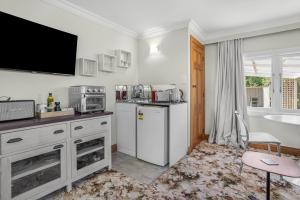 a kitchen with a white refrigerator and a sink at Farley Avenue Turret & Lounge in Greytown