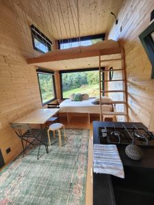 a bedroom in a tiny house with a bed and a table at Tiny House MOOSE HOME Les Chaumes in Les Ancizes-Comps