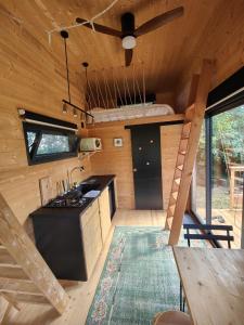 a kitchen in a tiny house with a ceiling fan at Tiny House MOOSE HOME Les Chaumes in Les Ancizes-Comps