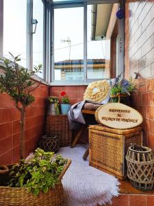 a balcony with plants and a bench and a window at El Hogarin de Veronica in Gijón