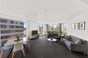 een woonkamer met een bank en een tafel bij Nook Melbourne Apartments : Jane Bell Lane - Melbourne CBD in Melbourne