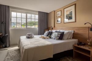 a bedroom with a bed with stuffed animals on it at Studios de Luxo Granja Brasil Itaipava in Itaipava