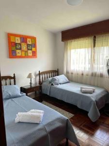 una camera da letto con due letti e una finestra di Alojamiento en Punta del Este con vista al mar a Punta del Este