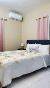 ein Schlafzimmer mit einem großen Bett mit einer weißen Bettdecke in der Unterkunft The shores in Montego Bay