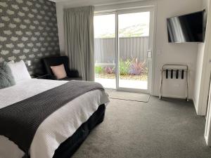 a bedroom with a bed and a sliding glass door at Lakeview Terrace Accommodation in Cromwell