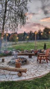 a fire pit in a park with a bench and a fire at Bobbie's Cottage - Bobijeva Vikendica in Antonići