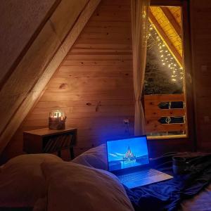 a laptop computer sitting on a bed in a room at Bobbie's Cottage - Bobijeva Vikendica in Antonići