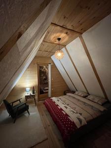 a bedroom with a large bed in a attic at Bobbie's Cottage - Bobijeva Vikendica in Antonići