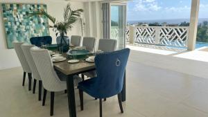 布里奇敦的住宿－Luxury 4 Bed Villa in Barbados with amazing views，享有海景的餐桌和椅子