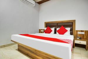 een slaapkamer met een groot bed met rode kussens bij Flagship Hotel Crown in Ludhiana