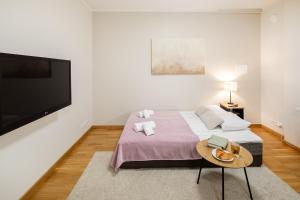 a bedroom with a bed and a flat screen tv at Riga Embassy center Apartment with parking in Rīga