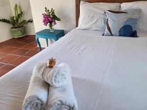 a bed with a towel animal sitting on top of it at Chalé Flor do Ser in Canoa Quebrada