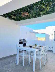 a white dining room with a white table and chairs at Luxury Penthouse Valentin with jacuzzi in Corralejo