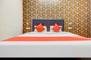1 dormitorio con 1 cama con almohadas de naranja y naranja en Flagship Hotel 3k Inn, en Ludhiana