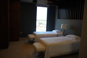 3 Betten in einem Zimmer mit Fenster in der Unterkunft Departamento entero de lujo in Los Mochis