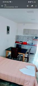 eine Küche mit einem Tisch und einem Tisch und Stühlen in der Unterkunft Apart Mi Kaú in Catriel