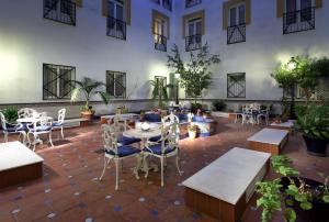patio ze stołami i krzesłami w budynku w obiekcie Eurostars Regina w Sewilli