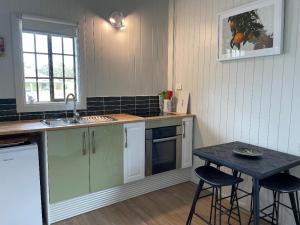 a kitchen with a sink and a table with stools at Straw House Farm - STANTHORPE in Dalveen