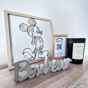 une étagère avec une photo de souris et une bouteille de vin dans l'établissement Beautiful apartment * parking* Disneyland 10 min, à Montévrain