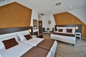 a hotel room with two beds and a table at Hotel Luxor Florence in Florence
