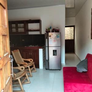 a kitchen with a refrigerator and chairs in a room at Alojamientos Fredys in El Socorro