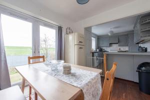 a kitchen with a wooden table and a kitchen with a refrigerator at Chingford charm great for families and contractors in Ponders End