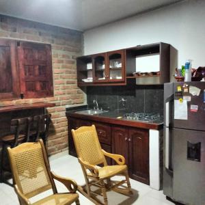 El Socorro的住宿－Alojamientos Fredys，厨房配有两把椅子和冰箱
