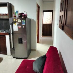 a kitchen with a stainless steel refrigerator and a red rug at Alojamientos Fredys in El Socorro