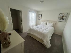 a white bedroom with a bed and a window at Home Sweet Home -San Antonio in San Antonio