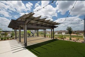 a wooden pergola on a patio with green grass at Home Sweet Home -San Antonio in San Antonio