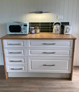 a white dresser with a microwave on top of it at Straw House Farm - STANTHORPE in Dalveen