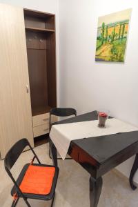 uma mesa e cadeiras num quarto com uma pintura em Simona Studio em Bucareste