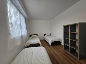 a bedroom with two beds and a window at Grand appartement 160m2 equipped for professionnal groups in Sarcelles