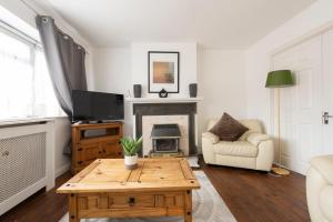 a living room with a coffee table and a fireplace at Chingford charm great for families and contractors in Ponders End