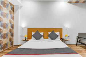 a bedroom with a white bed with a wooden headboard at Collection O Hotel Landmark in Lucknow